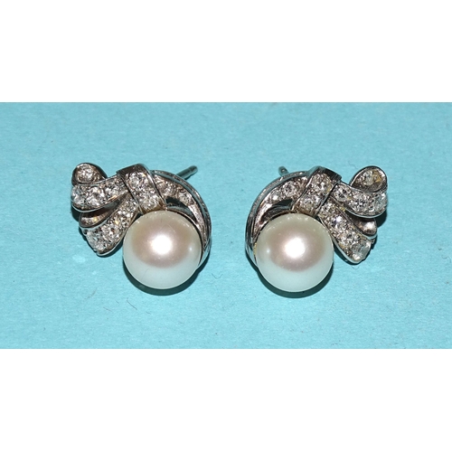 483 - A pair of cultured pearl and diamond earrings, each set with a white pearl, approximately 8mm, in un... 