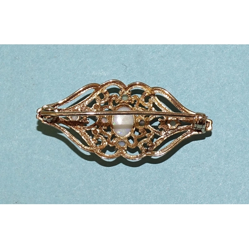 519 - A 9ct gold brooch of scrolling form set opal cluster, 38 x 16mm, 3.6g.