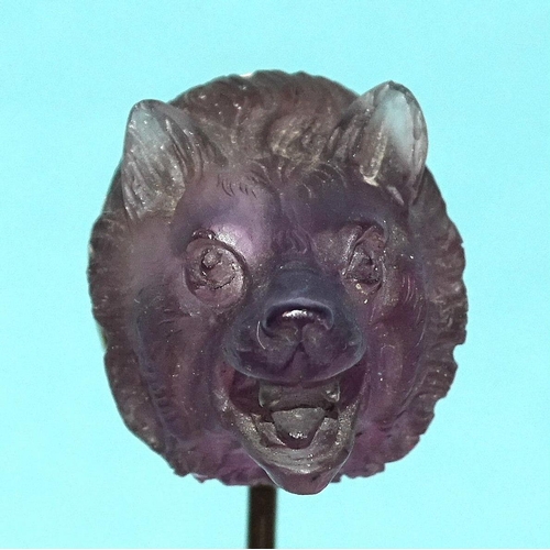 596 - A Queen Victoria interest gold stick pin surmounted by a carved amethyst wolf's head, the mount engr... 