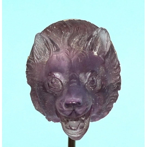 596 - A Queen Victoria interest gold stick pin surmounted by a carved amethyst wolf's head, the mount engr... 