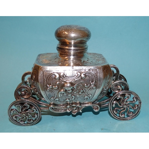 759 - A silver inkwell of Baroque form, raised on ornate carriage with four wheels, 9cm high, 12.5cm long,... 