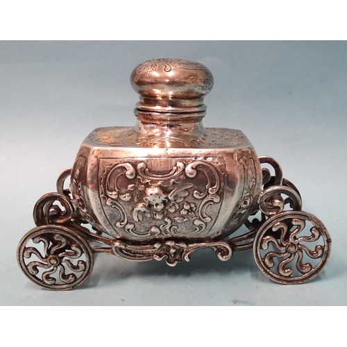 759 - A silver inkwell of Baroque form, raised on ornate carriage with four wheels, 9cm high, 12.5cm long,... 