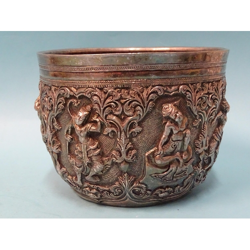 767 - A Burmese silver bowl deeply embossed with deities within scrolling arches, 12.5cm diameter, 9.5cm d... 