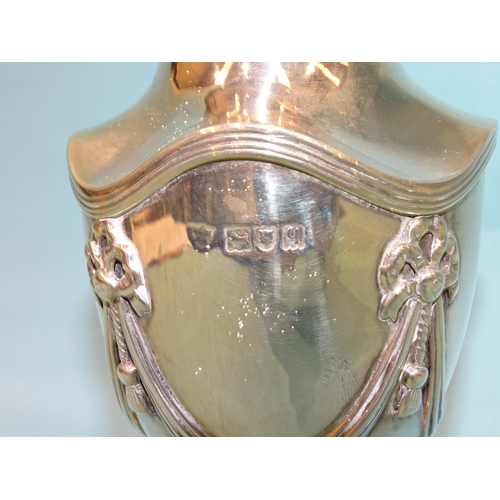 789 - A silver sugar sifter of urn form with applied swag and tassel decoration, raised on square foot, ma... 