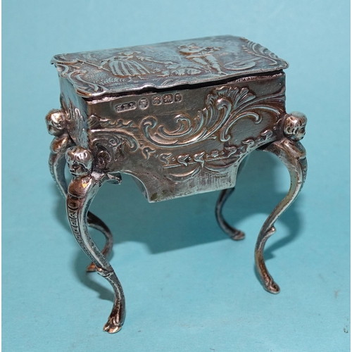 917 - A Continental silver pill box in the form of a worktable, on cabriole legs, with embossed decoration... 