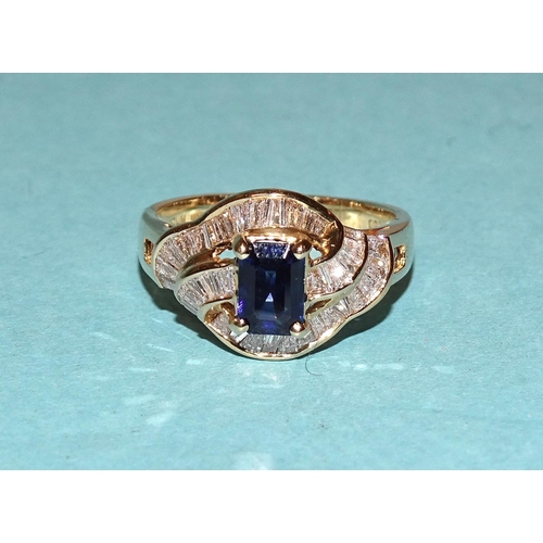 447 - A sapphire and diamond cluster ring claw-set a step-cut sapphire amid three wavy lines of channel-se... 