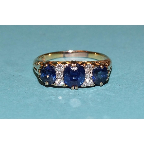 459 - A sapphire and diamond ring set three sapphires with trios of diamonds between, in unmarked gold mou... 
