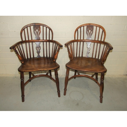 18 - A pair of 19th century yew wood comb-back Windsor chairs, with shaped elm seats and crinoline stretc... 