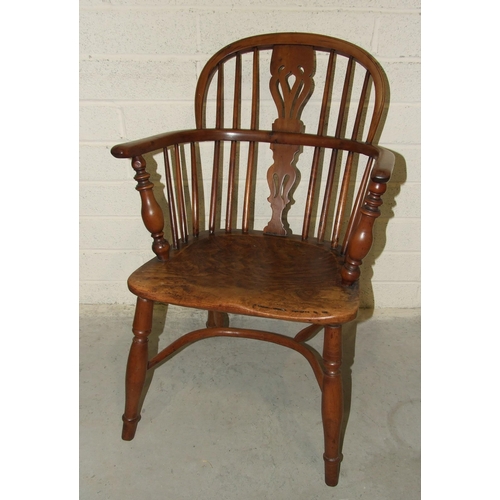 19 - A 19th century yew wood comb-back Windsor chair with shaped elm seat.