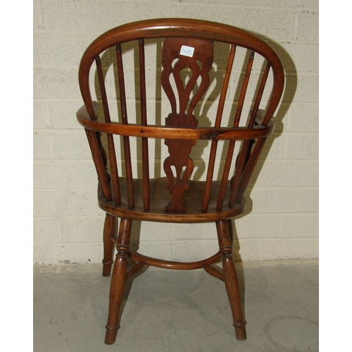 19 - A 19th century yew wood comb-back Windsor chair with shaped elm seat.