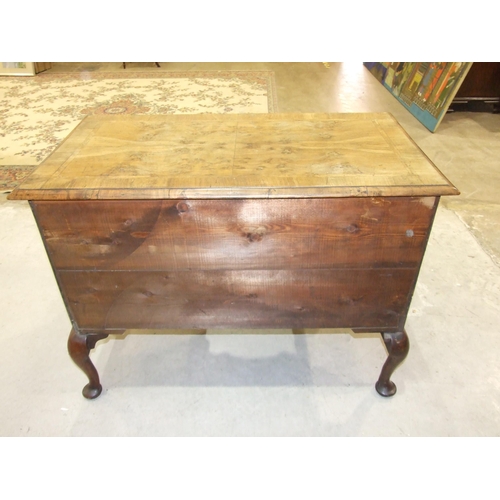 22 - An antique walnut feather-banded lowboy, the rectangular quarter-veneered top with moulded edge, abo... 