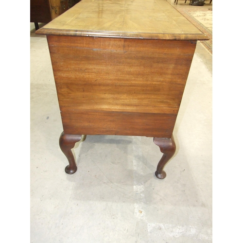 22 - An antique walnut feather-banded lowboy, the rectangular quarter-veneered top with moulded edge, abo... 
