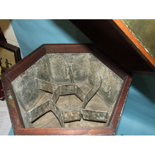 23 - A George III brass-bound mahogany cellarette of hexagonal shape, with lift lid enclosing a lead-line... 