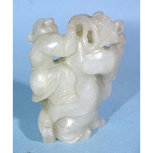 284 - A Chinese carved jade figure of a man carrying a child, with a goat at his feet, 5cm high.... 