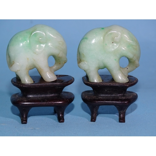 285 - Two carved jade elephants on stands, 4.8cm overall, (3).