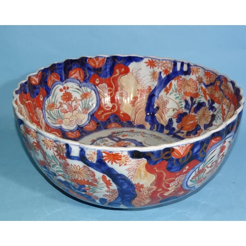 350 - A large Japanese Imari porcelain fluted punch bowl decorated with vases of flowers, 33cm diameter.... 