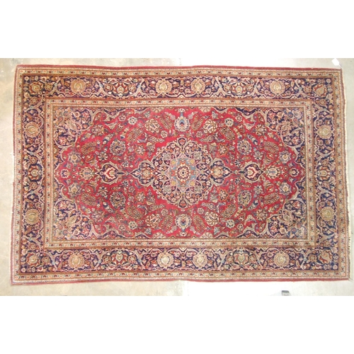 39 - An early to mid-20th century Persian rug, the symmetric design with pole medallion on crimson and bl... 
