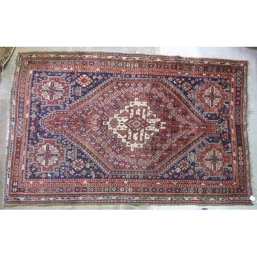 41 - A 20th century Persian wool rug, the central lozenge within a multiple border, on red and blue groun... 