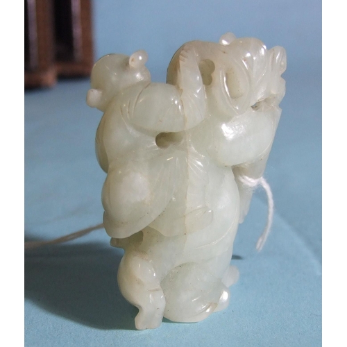 284 - A Chinese carved jade figure of a man carrying a child, with a goat at his feet, 5cm high.... 