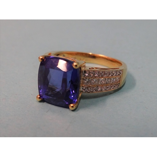 598 -  A Tanzanite and diamond ring, claw set a cushion cut Tanzanite of approx 8cts  between shoulders se... 