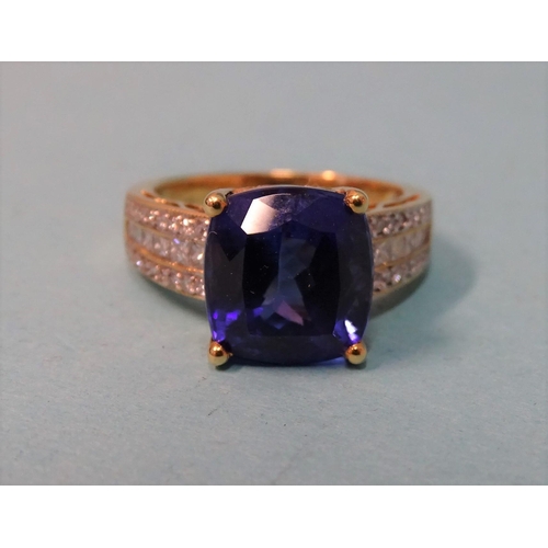 598 -  A Tanzanite and diamond ring, claw set a cushion cut Tanzanite of approx 8cts  between shoulders se... 