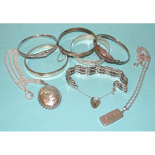 192 - Five various silver bangles, a silver gate-link bracelet, a silver locket on chain, 130g and an ingo... 