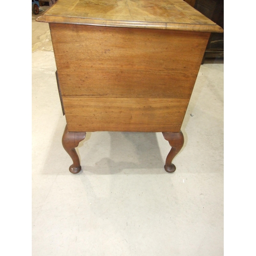 110 - An antique walnut feather-banded lowboy, the rectangular quarter-veneered top with moulded edge, abo... 