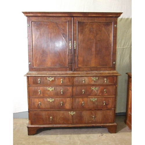 115 - An early-18th century walnut press cupboard, the moulded cornice above two panelled doors, the lower... 