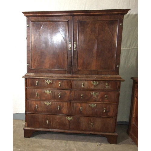 115 - An early-18th century walnut press cupboard, the moulded cornice above two panelled doors, the lower... 