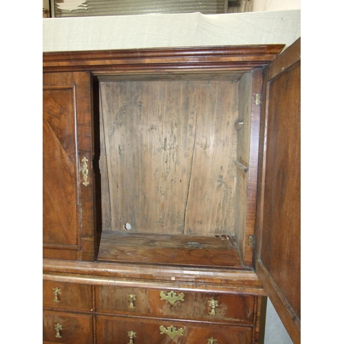 115 - An early-18th century walnut press cupboard, the moulded cornice above two panelled doors, the lower... 