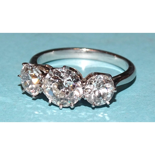 A three-stone diamond ring claw-set brilliant-cut diamonds of approximately 0.65cts, 1.2cts and 0.7cts, in platinum mount, hallmarked London 1991, maker RO, size N½, 5.2g.