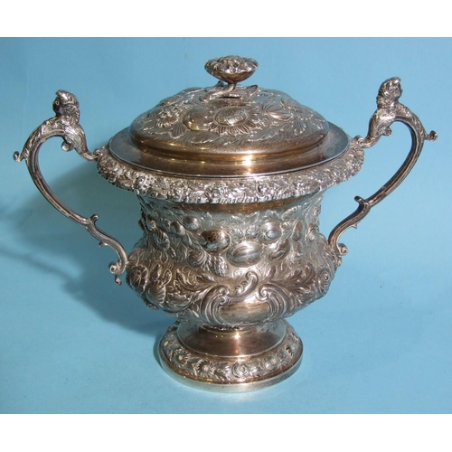 563 - A William IV silver porringer and cover, of bellied form with scrolling caryatid handles, embossed o... 