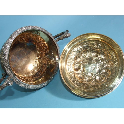 563 - A William IV silver porringer and cover, of bellied form with scrolling caryatid handles, embossed o... 