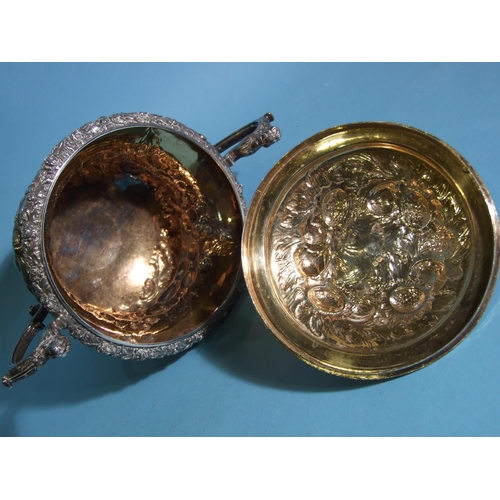 563 - A William IV silver porringer and cover, of bellied form with scrolling caryatid handles, embossed o... 