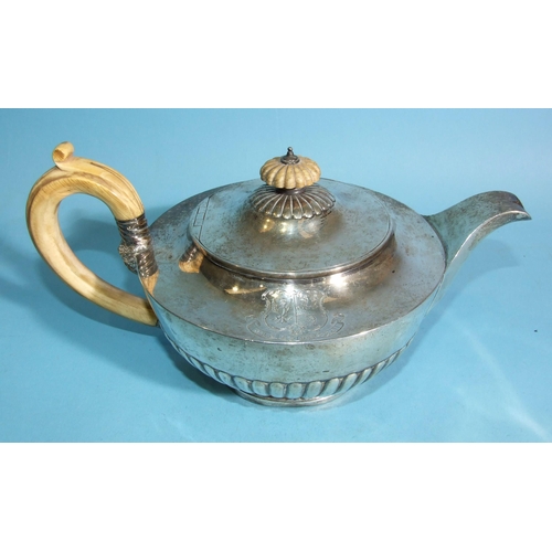 564 - A George III silver teapot of compressed half-gadrooned form, with ivory and mask handles, engraved ... 