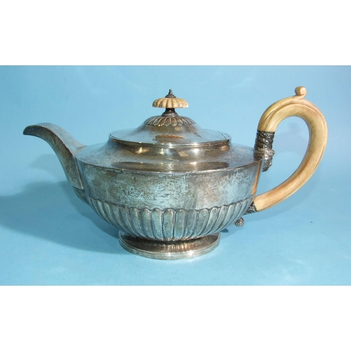 564 - A George III silver teapot of compressed half-gadrooned form, with ivory and mask handles, engraved ... 