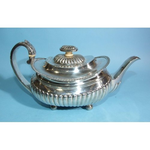 566 - A George III silver teapot of oval boat shape, with half-reeded decoration and leaf-capped C-scroll ... 