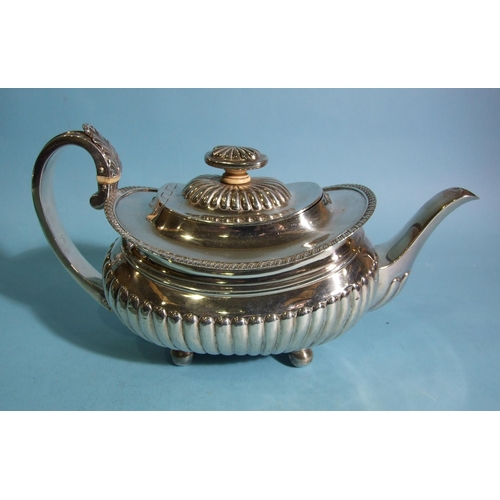 566 - A George III silver teapot of oval boat shape, with half-reeded decoration and leaf-capped C-scroll ... 