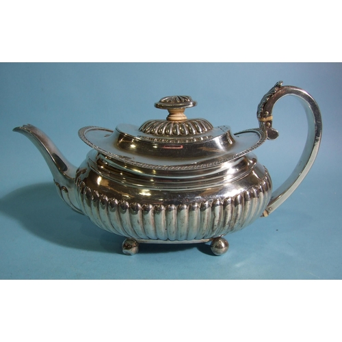 566 - A George III silver teapot of oval boat shape, with half-reeded decoration and leaf-capped C-scroll ... 