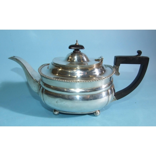 567 - A 20th century plain teapot with gadrooned border, on ball feet, with black handle and finial, Londo... 