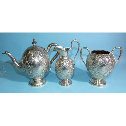 586 - A Victorian silver teapot of ovoid form with all-over decoration of flowers and scrolls, on circular... 