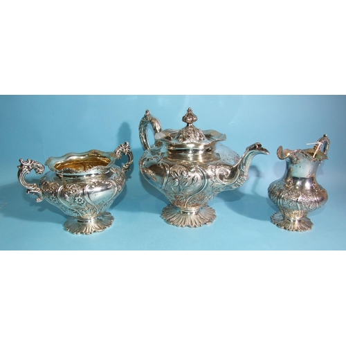 587 - A William IV three-piece silver tea service with embossed and chased foliate and scroll decoration, ... 