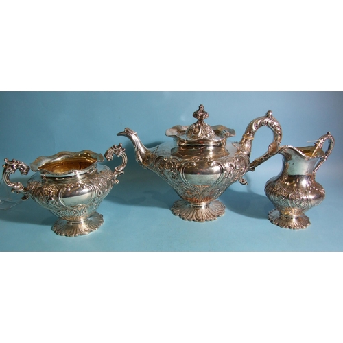 587 - A William IV three-piece silver tea service with embossed and chased foliate and scroll decoration, ... 