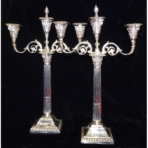 589 - A pair of late-Victorian silver three-branch candelabra, on Corinthian columns and square loaded bas... 