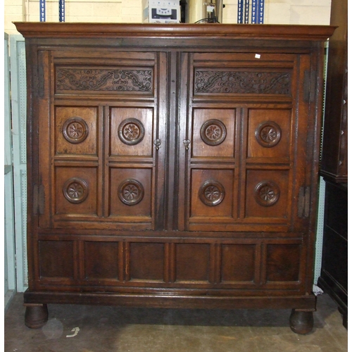 79 - A large antique oak two-door food cupboard, with later cornice above a pair of carved panelled doors... 