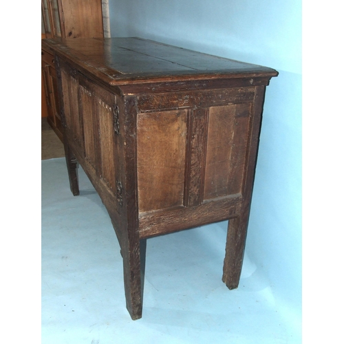 99 - An antique oak side cupboard, having a pair of linen-fold doors, on extended stile supports, 150cm w... 