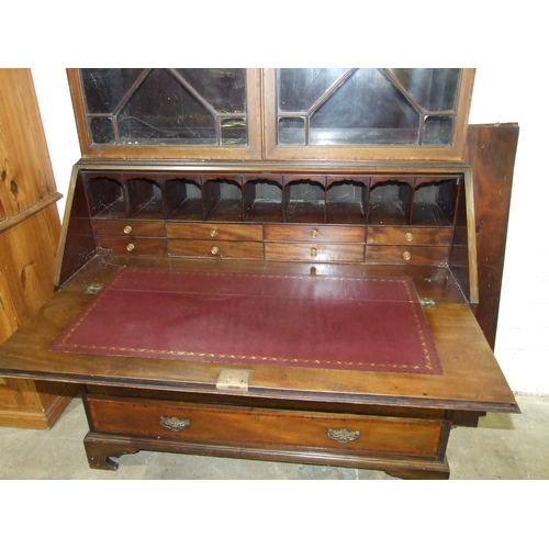 101 - A large mahogany cross-banded bureau/bookcase, the pediment above a pair of astragal-glazed doors, w... 