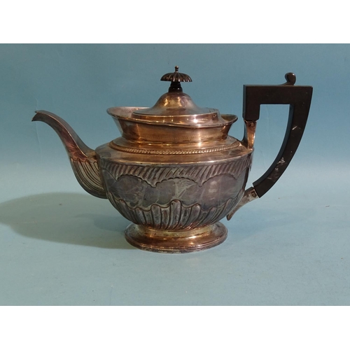 565 - A Victorian silver teapot of circular form with partial-gadrooned decoration, armorial and black han... 