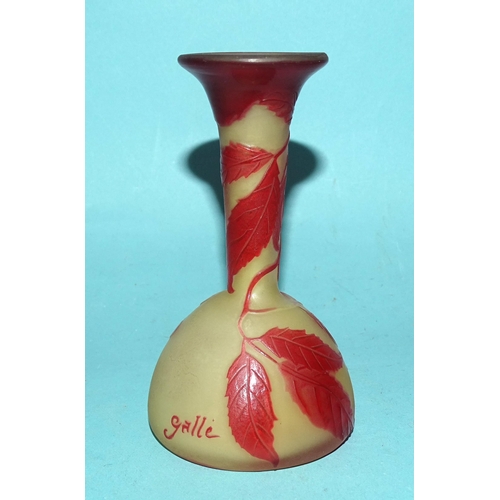 132 - A small cameo glass bud vase in mustard yellow opaque glass, with red overlay etched leaf and berry ... 