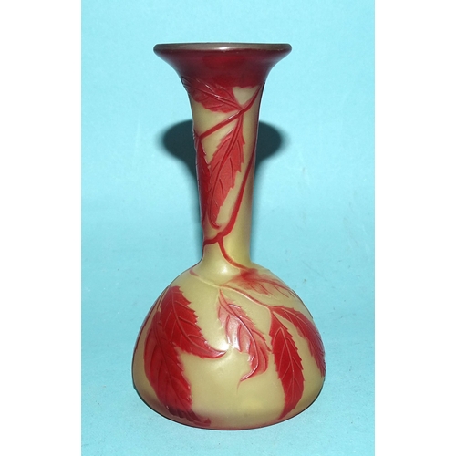 132 - A small cameo glass bud vase in mustard yellow opaque glass, with red overlay etched leaf and berry ... 